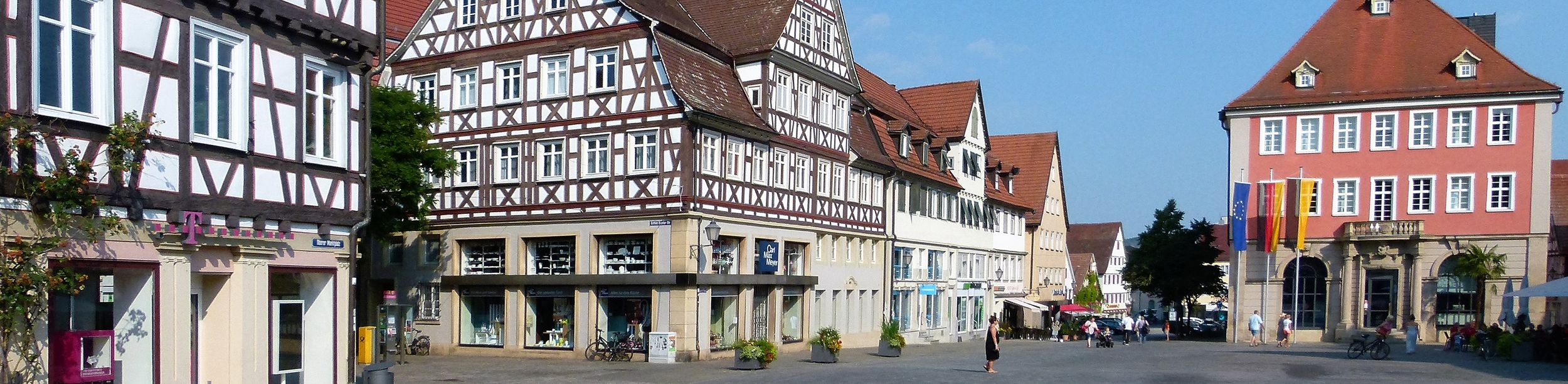 Fachwerkhäuser und Rathaus mit Uhr am sonnigen Marktplatz